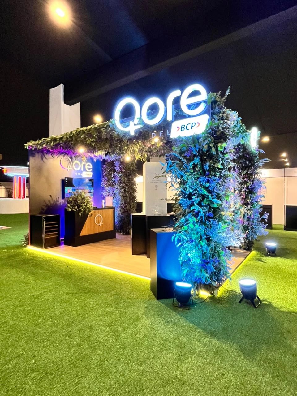 Lounge Qore del BCP con jardín vertical, de noche